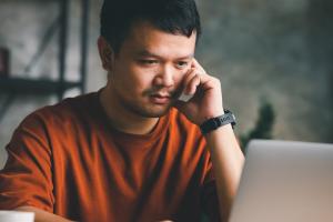 Man focused on reading article about Splashtop Remote Support SOS on computer screen