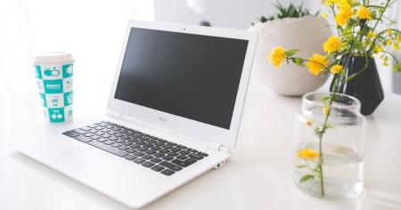 A Chromebook sitting on a desk in a home office.